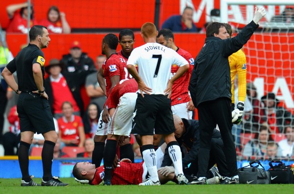 Rooney được các bác sĩ băng bó vết thương...